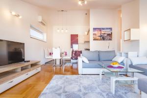 a living room with a couch and a tv at Villa Apartments Futura in Vantačići