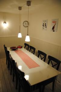 a dining room table with chairs and a clock on the wall at Vakantiehuis Ramsbeck in Ramsbeck