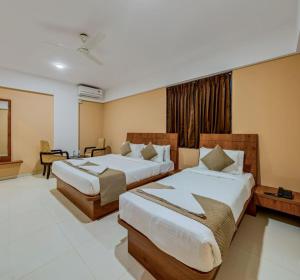 a hotel room with two beds in a room at Hotel Grand Heritage Badami in Badami
