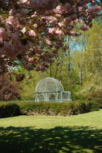 a gazebo in the middle of a field with a tree at Waldorf Astoria Versailles - Trianon Palace in Versailles