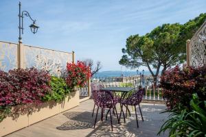 a table and chairs on a balcony with flowers at Hotel Vittorio in Desenzano del Garda