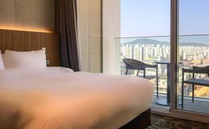 a hotel room with a bed and a large window at Hotel Editions Mokpo in Mokpo
