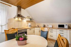 a kitchen with a table and a stove and microwave at Ferienwohnung Niemeier in Brilon