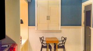 a table and two chairs in a kitchen with blue walls at 747 Motel in Gimcheon