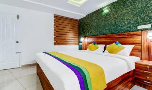a bedroom with a large bed with a colorful blanket at Itsy Hotels Dew Dreams in Cochin