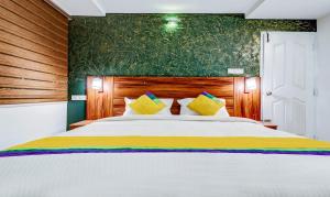 a bedroom with a large white bed with yellow pillows at Itsy Hotels Dew Dreams in Cochin
