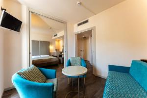 a living room with blue chairs and a table at Hotel Vittorio in Desenzano del Garda