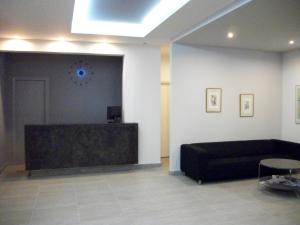 sala de estar con sofá negro y pared en Hotel Benitses Arches, en Benitses