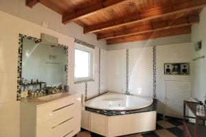a bathroom with a large tub and a large mirror at Oasis con piscina y jacuzzi para 4 in Adsubia