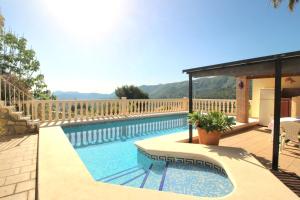 a swimming pool in a backyard with a wooden fence at Oasis con piscina y jacuzzi para 4 in Adsubia