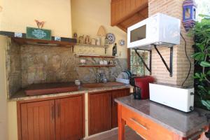 a kitchen with wooden cabinets and a microwave on a counter at Oasis con piscina y jacuzzi para 4 in Adsubia
