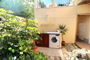 a washing machine in a yard with plants at Oasis con piscina y jacuzzi para 4 in Adsubia