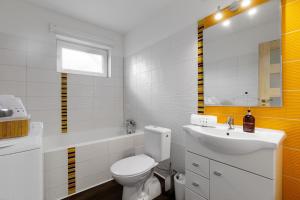 a white bathroom with a toilet and a sink at Komfortný apartmán s bazénom a súkromným parkoviskom - 24h self check-in in Banská Bystrica