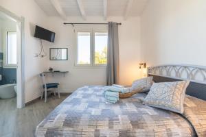 a bedroom with a large bed and a television at Moon - Rooms in Quartu SantʼElena