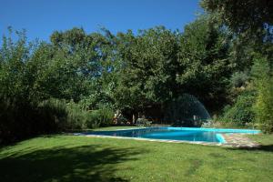 a swimming pool in a yard with trees and grass at Casas Arbillas in Arenas de San Pedro