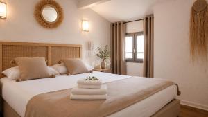 a bedroom with a large bed with towels on it at Les Jardins de L'Ocean - Climatisé in Biscarrosse-Plage