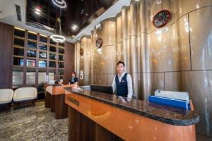 two people are standing at a counter in a room at WYNNE Hotel Nha Trang in Nha Trang
