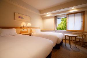 a hotel room with two beds and a window at Hotel New Otani Hakata in Fukuoka