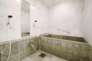 a bathroom with a tub and a shower with a mirror at Hotel New Otani Hakata in Fukuoka