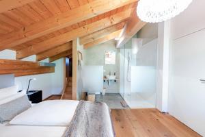 a bedroom with a white bed and wooden ceilings at Loft7 in Mittelberg