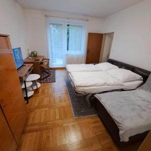 a bedroom with two beds and a desk with a computer at Apartmán Ševcovská in Zlín