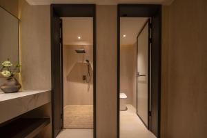 a bathroom with a toilet and a walk in shower at Liaoxin Valley Forest Hotel in Jiezi Ancient Town +79 photos