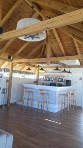 a kitchen with a bar with stools under a wooden ceiling at Le Clos des Bains Mauritius in Blue Bay