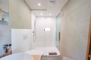 a white bathroom with a shower and a toilet at Loft7 in Mittelberg +26 photos