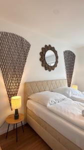 a bedroom with a bed with a mirror and a table at AMAO-Ivory - Business Apartment - 6 Guests - Parking in Offenburg