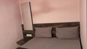a bed in a room with two pillows on it at Hotel M N Matheran in Matheran +16 photos