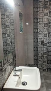 a bathroom with a white sink and a mirror at Hotel M N Matheran in Matheran