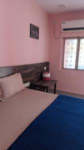 a bedroom with a bed and a table and a window at Hotel M N Matheran in Matheran