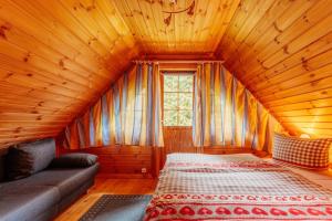 a bedroom with a bed and a couch in a room at Der Fuchsbau - 3 Blockhäuser in Bad Sachsa +124 photos