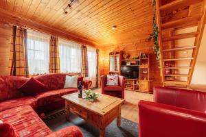 a living room with a couch and a coffee table at Der Fuchsbau - 3 Blockhäuser in Bad Sachsa