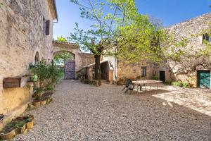 a courtyard of an old stone building with a table at Appartement 1 in Sauzet