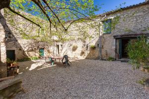 a patio with a table and chairs in front of a building at Appartement 2 in Sauzet