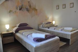 two twin beds in a room with two lamps at Migazzi Vendégház in Vác