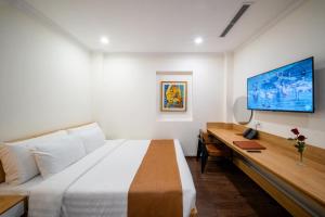a bedroom with a large bed and a desk at WYNNE Hotel Nha Trang in Nha Trang