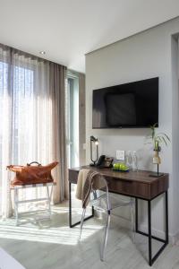 a room with a desk and a television on a wall at Zest Boutique Hotel by The Living Journey Collection in Cape Town