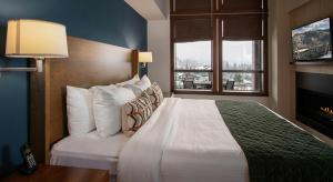 ein Hotelzimmer mit einem großen Bett und einem Kamin in der Unterkunft Evolution Whistler, by Lodging Ovations in Whistler