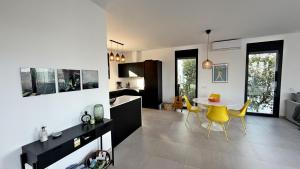 a kitchen and living room with a table and yellow chairs at Villa Titulabo in Orba