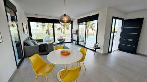 a dining room with a white table and yellow chairs at Villa Titulabo in Orba