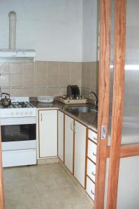 una cocina con fregadero y estufa en Cedro Departamentos Temporarios, en Posadas 7 fotos más