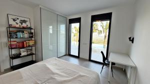 a bedroom with a bed and a desk and a window at Villa Titulabo in Orba +26 photos