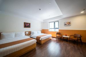 a hotel room with two beds and a window at WYNNE Hotel Nha Trang in Nha Trang +89 photos