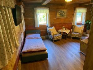 a room with two beds and a table and chairs at Apartmán Rozárka Chřibská in Nieder Kreibitz