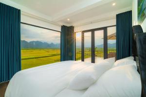 a bedroom with a bed and a large window at Karst Residence Phong Nha in Phong Nha