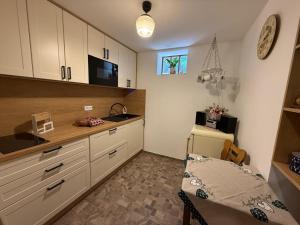 a kitchen with white cabinets and a table in it at Apartmán Rozárka Chřibská in Nieder Kreibitz