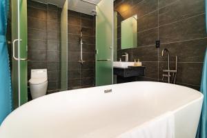 a bathroom with a tub and a sink and a toilet at Karst Residence Phong Nha in Phong Nha