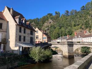 a bridge over a river in a town with buildings at Studio à l'entrée de ma maison in Aubusson